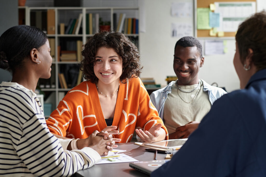 Peer mentoring in action as a small group meets to share ideas, guidance, and support during a collaborative discussion.