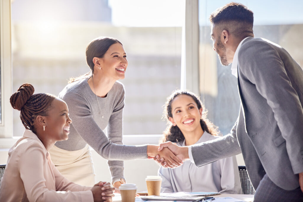 A confident handshake closes the deal in a bright office meeting, showcasing direct sales in action.